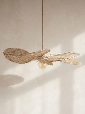 Lampa wisząca kwiat Kipas z rattanu na tle beżowej ściany.