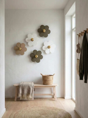 Lampy ścienne w kształcie kwiatów z białym i zielonym kolorze w przedpokoju nad ławką.