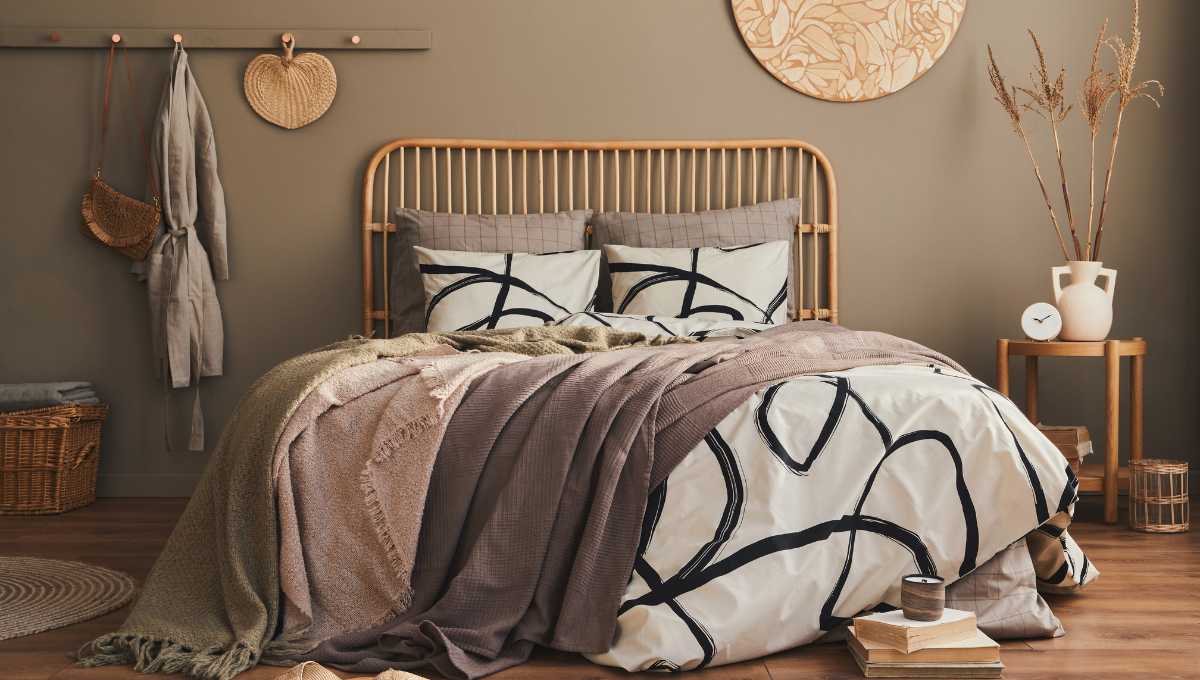 Łóżko rattanowe na tle ciemnobeżowej ściany.