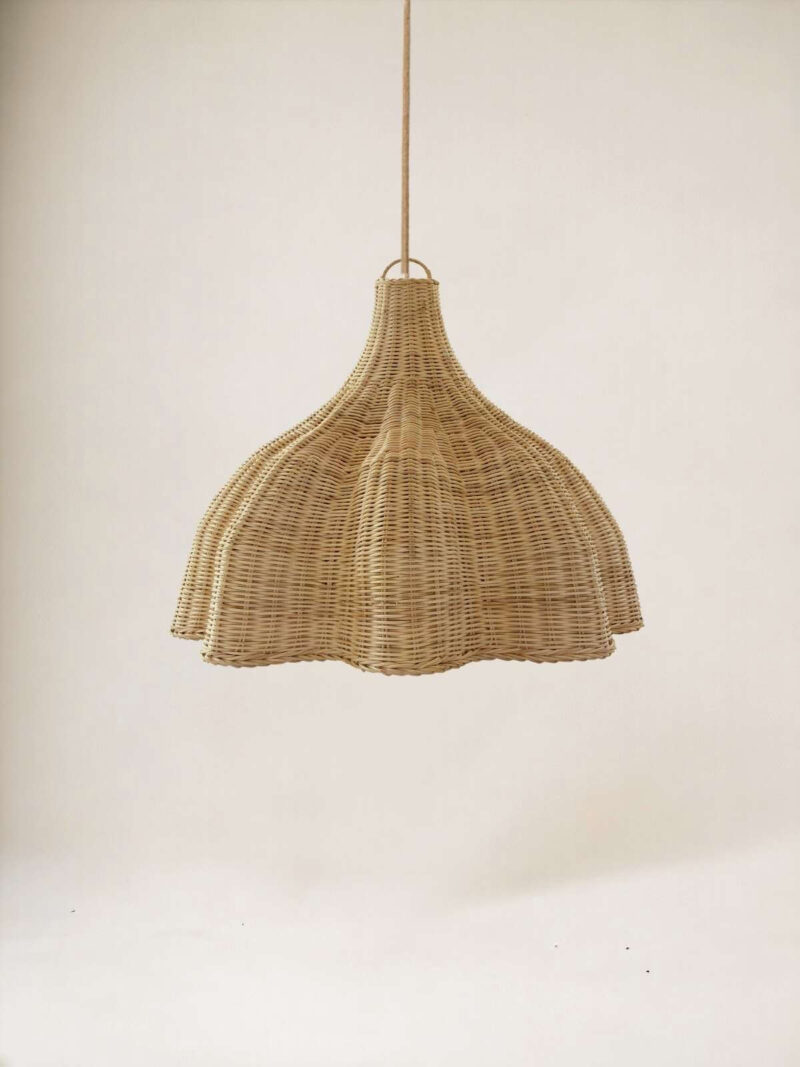 Lampa wisząca Bunga z rattanu na tle jasnej ściany.