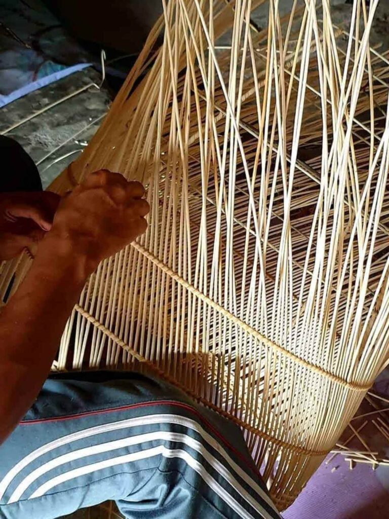 craftsman-mezczyzna-splata-lampe-z-rattanu