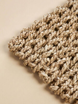 Zbliżenie na splot chodnika sizalowego ja jasno-beżowym tle.