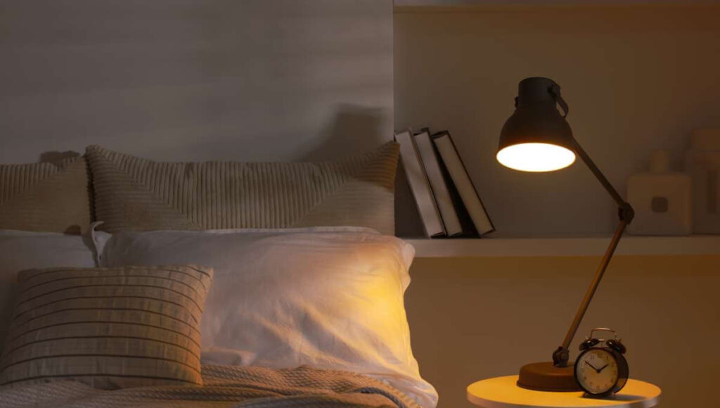 Nastrojowe światło padające na poduszkę w lnianej poszewce.