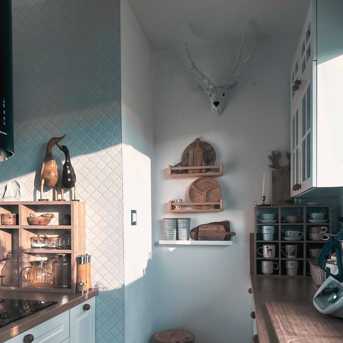 Kuchnia jednej z klientek, która postawiła dwie drewniane kaczki z Bali na regale z kubkami.